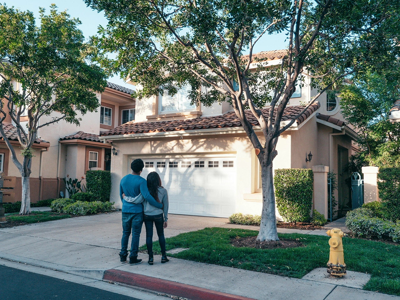 Couple in front looking at their new property