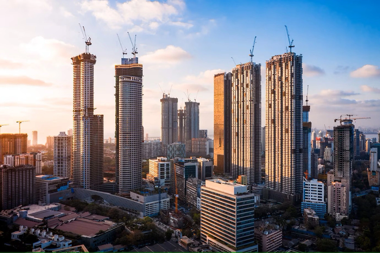 High-rise buildings under construction in a city skyline at sunset