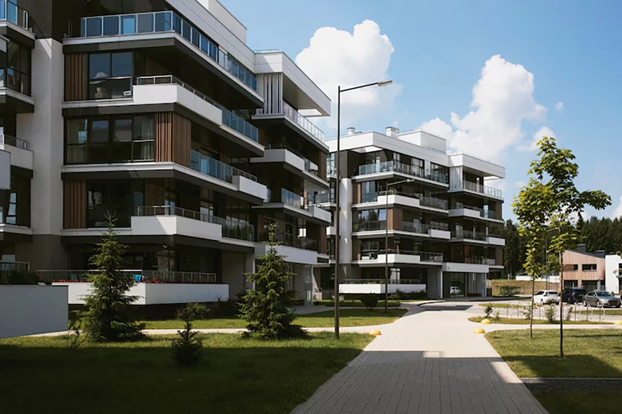 Modern apartment buildings with glass balconies and landscaped walkways.