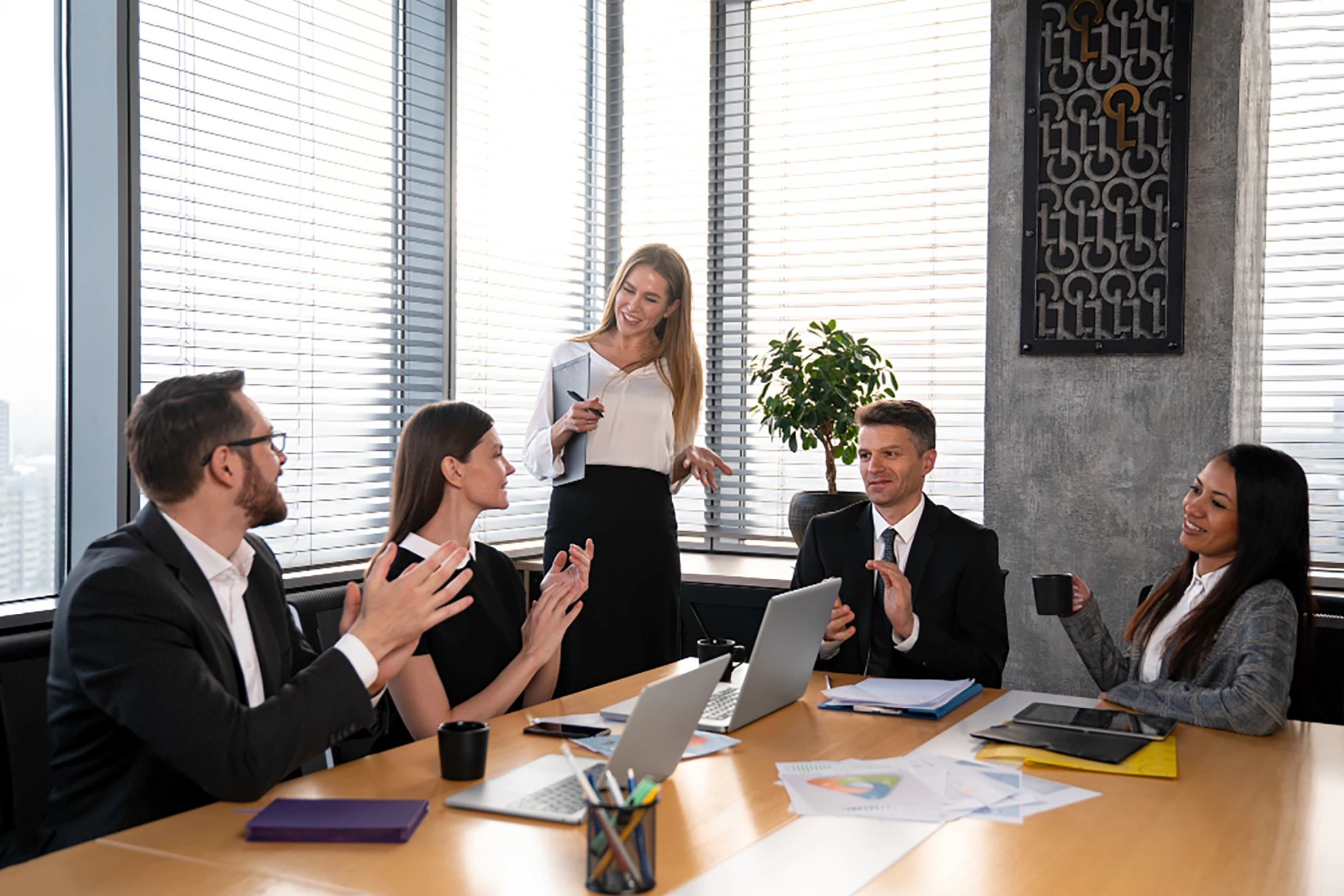 Business team having a meeting in a modern office, smiling and applauding