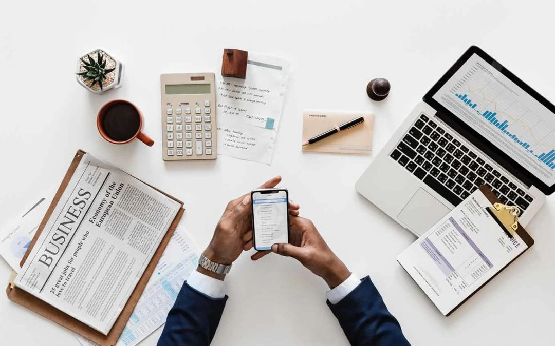 Real estate man with a phone in his hand and on a desk.