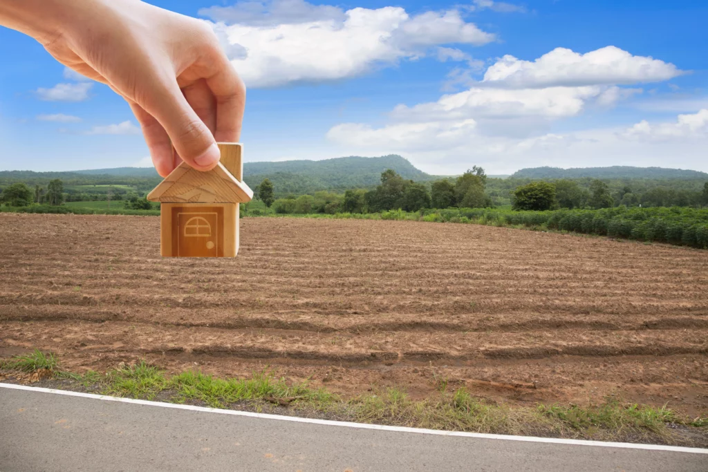 a landscape with a hand holding a house