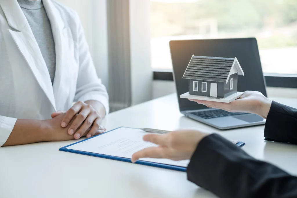 a real estate agent selling land, holding a house