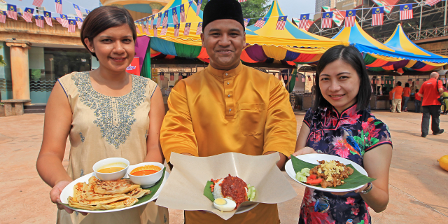 Malaysian holding the Malaysia's national dish: roti canai and nasi lemak
