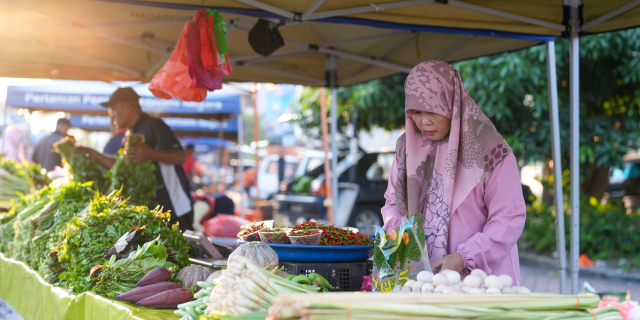 a woman selling vegetables at the market