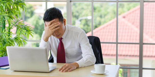 男人在桌前扶额烦恼